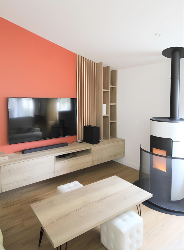 Salon moderne avec mur orange, poêle à bois design et meuble TV en bois clair