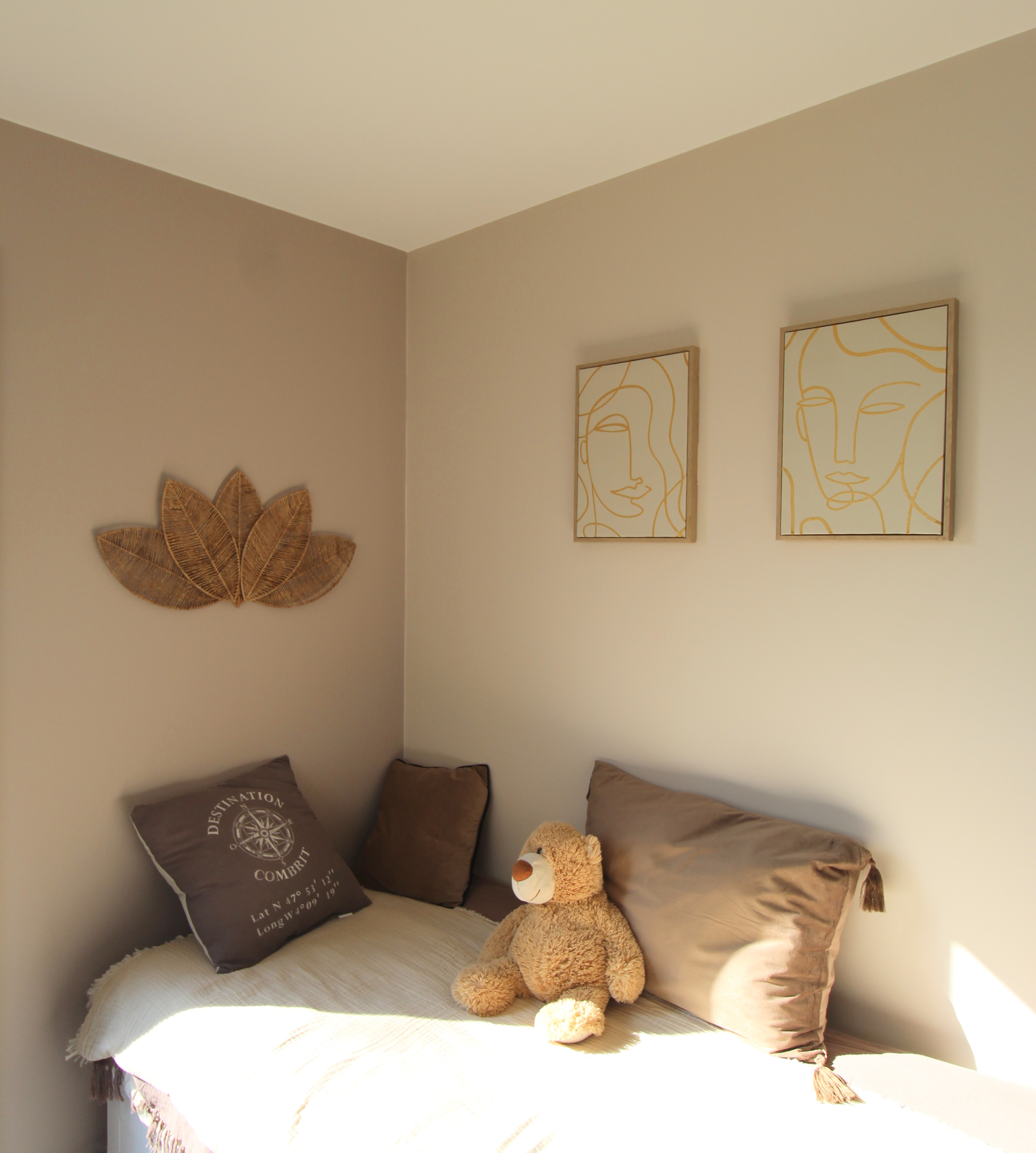 Chambre cosy avec lit simple, coussins bruns, ours en peluche et décorations murales modernes