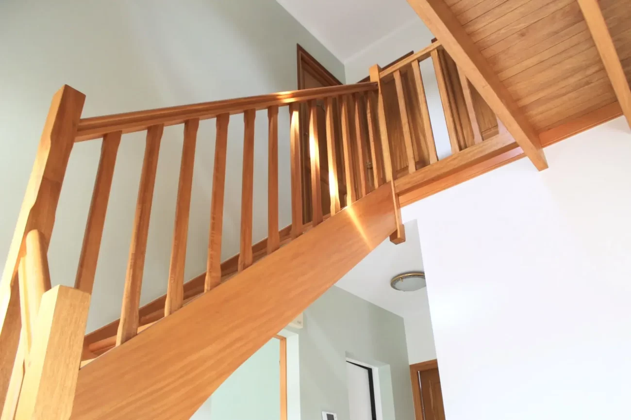 Escalier intérieur en bois avec rambarde et plafond assorti